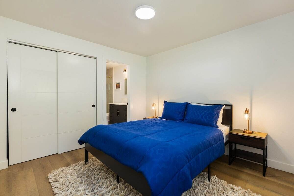 A bedroom with a bed, bedside tables, a wardrobe, and a light fixture.