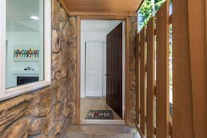 A stone exterior wall, a wooden door, and a doormat with "home" written on it. - Stylish Eastside 3BR Family Home - Prime Location! (Bellevue)