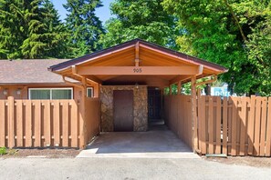 A covered entrance to a building with a stone wall and a wooden door, surrounded by a wooden fence. - Stylish Eastside 3BR Family Home | Prime Location! (Bellevue)