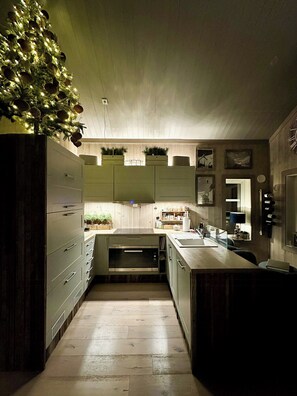 A kitchen with wooden cabinets, a central island, and a small Christmas tree. - Modern mountain cabin near Nesfjellet golf course (Nesbyen)