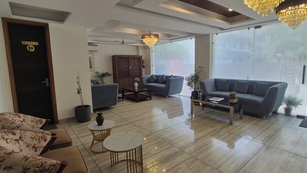 Een moderne woonkamer met een bank, salontafel en een kroonluchter.