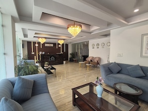 Um hall de hotel moderno com balcão de recepção, área de estar e um candelabro.