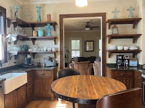 A kitchen with wooden cabinets, a round dining table, and various kitchen appliances.