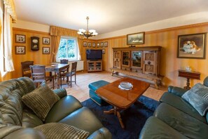 A living room with a sofa, a coffee table, a TV, and a cabinet. - Apartment Josephine (Torgau)