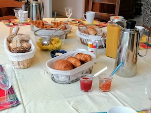 Un buffet de petit-déjeuner proposant une variété de pains, de viennoiseries et d’accompagnements.