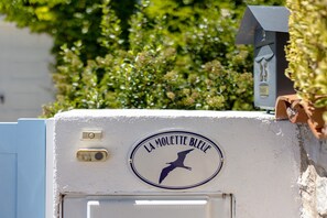 La façana d'un edifici amb un senyal circular que diu 'LA MOUETTE BLEUE' i la silueta d'un ocell.