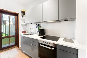 A modern kitchen with a built-in stove, a sink, and a dishwasher. - GuestReady - Oporto Breiner Terrace (Porto)