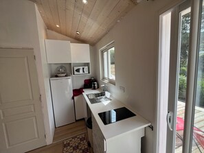 Eine kompakte Küche mit Kühlschrank, Mikrowelle und Herd.