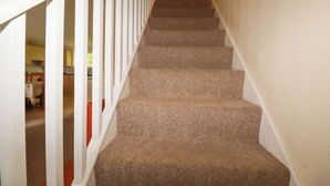 A carpeted staircase with white railings leading to an upper floor. - 20 Atlantic Reach (St. Columb Major)