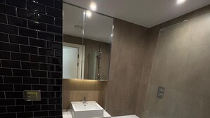 Een moderne badkamer met toilet, wastafel en bad.