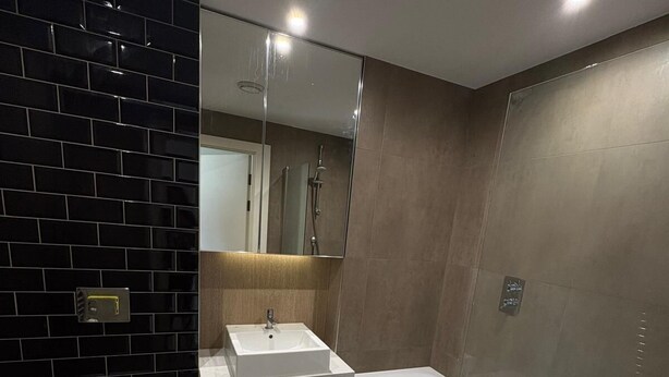 Een moderne badkamer met toilet, wastafel en bad.