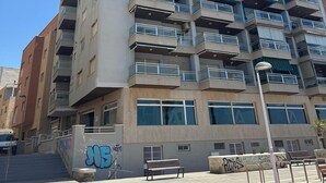 A multi-story residential building with balconies, a staircase leading to the entrance, and a graffiti-covered wall. - Apartment on the beach - Paseo marítimo de Almería (Almería)
