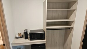 A kitchenette with a microwave, coffee maker, and trash bin. - Cozy 7-Room Boutique Motel (Estelline)