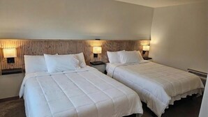 A hotel room with two beds, each with a headboard and bedside lamps. - Cozy 7-Room Boutique Motel (Estelline)