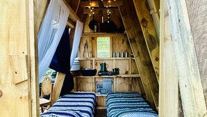 A cozy attic bedroom with two beds, a small kitchenette, and a ceiling light fixture. - A-frame in Indian Lake+Pet Friendly+Lake Front (Indian Lake)