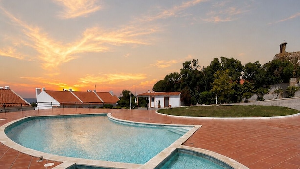 Una piscina dalle linee curve, circondata da piastrelle in terracotta.