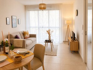 Un salon moderne avec un canapé, une table à manger et un meuble pour la télévision.