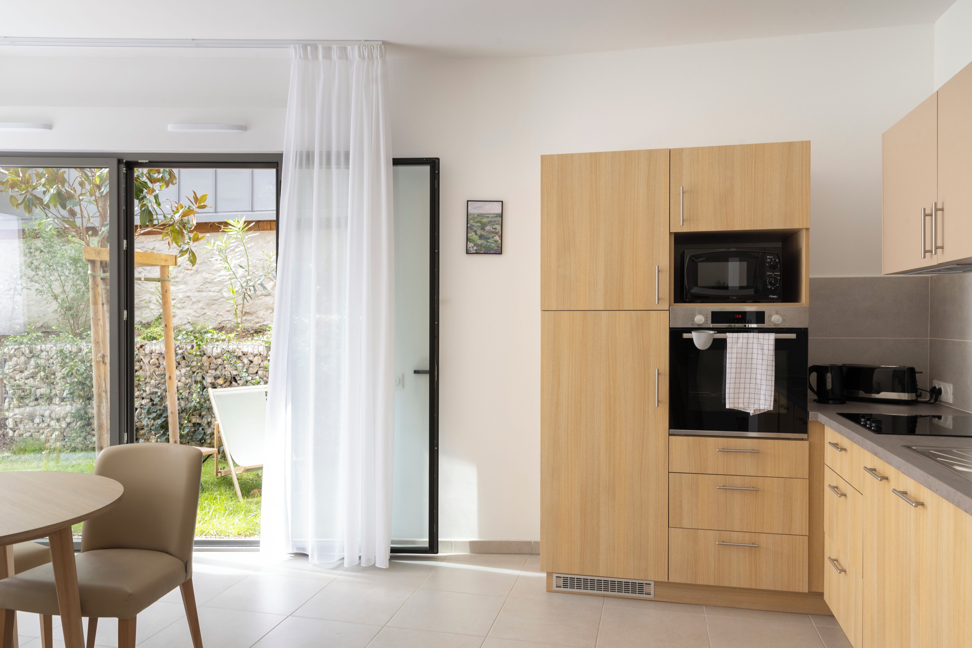 Una cocina moderna con armarios de madera, un microondas y una estufa.
