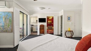 A hotel room with a large bed, a television, a map on the wall, and a kitchenette. - Glebe Corner Walkable City Fringe Base with Pool (Glebe)
