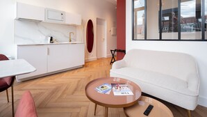 Una sala de estar moderna con un sofá, una mesa de centro, una mesa de comedor y una zona de cocina.