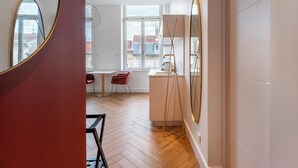 Un interior moderno con zona de comedor, una lámpara de pie y vistas por una ventana.