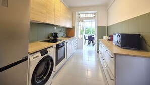 A compact kitchen with a washing machine, a microwave, and a sink. - Rock in Share - Strozzi Suites - Brand-New Luxury 4-Bedroom Apartment with (Thionville)