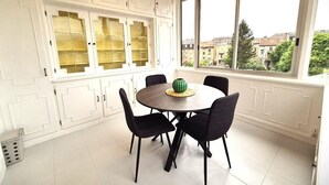 A dining area with a round table, black chairs, and a green vase. - Rock in Share - Strozzi Suites - Brand-New Luxury 4-Bedroom Apartment with (Thionville)