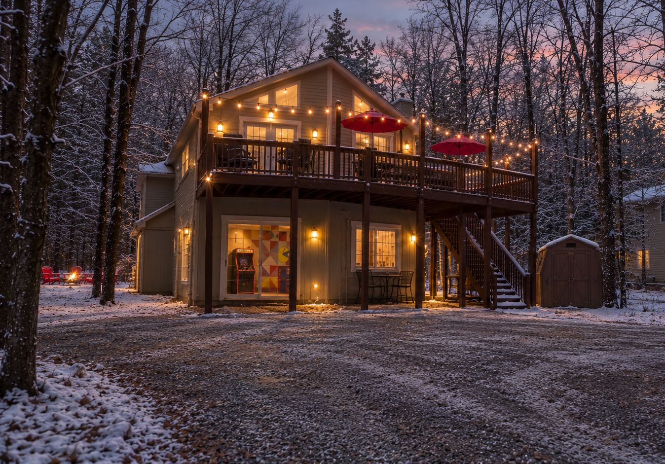 A two-story cabin with a balcony, a fire pit, and a covered outdoor seating area.