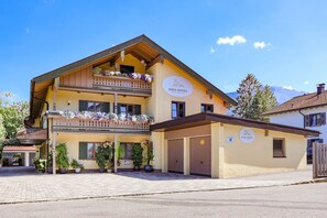 A two-story building with a sign reading 'HAUS DIPPEL' and a parking sign. - Apartment Unternberg (Ruhpolding)