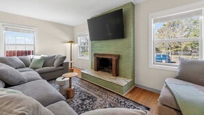 A living room with a fireplace, a flat-screen TV, and a sofa. - 6 beds / close to SCSU, DT, & Lake George (St. Cloud)