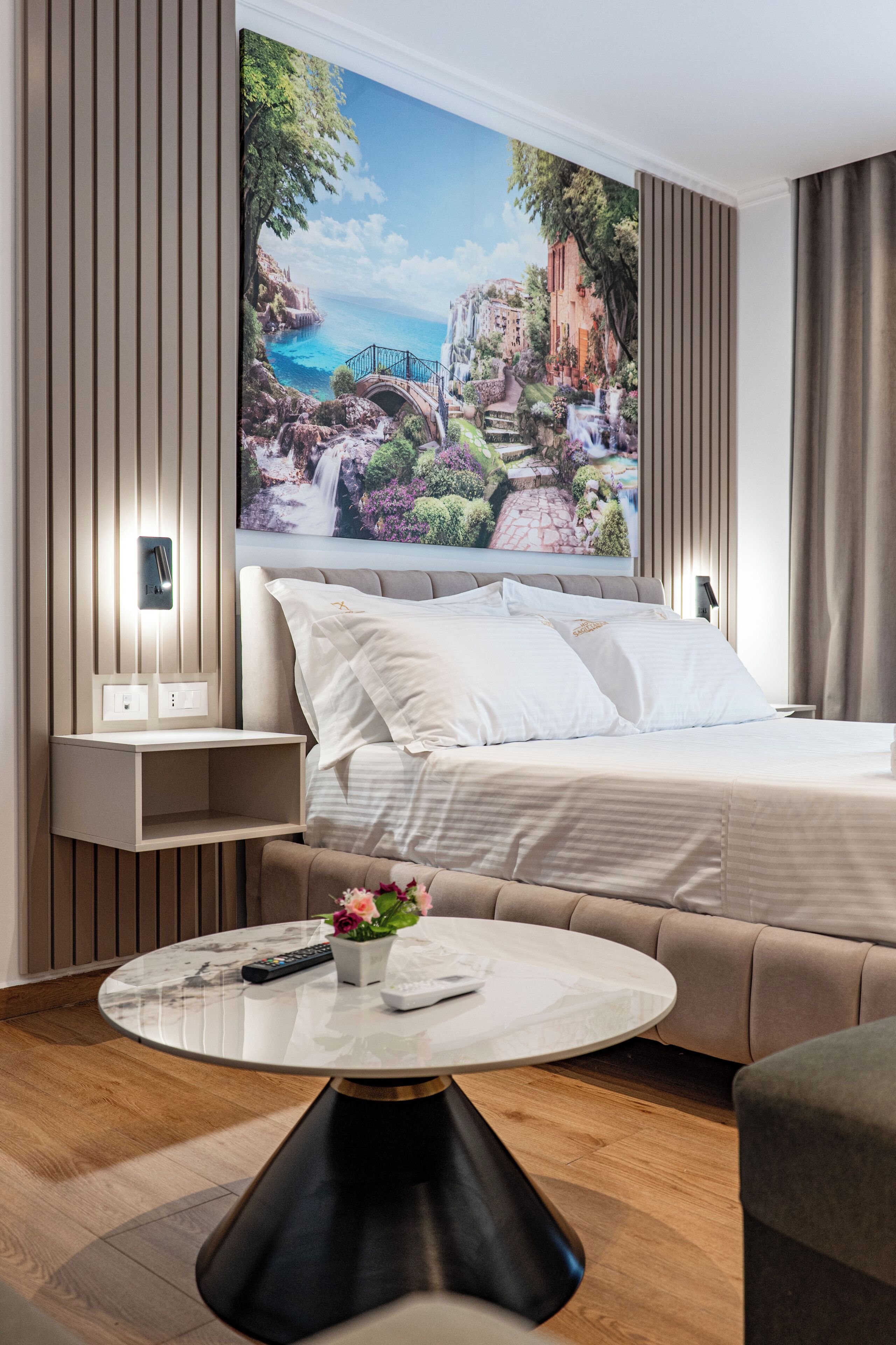Una habitación de hotel moderna con una cama, una mesita de noche y una mesa redonda de centro.