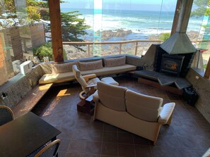 A cozy seating area with a stone fireplace, a sofa, and a table.