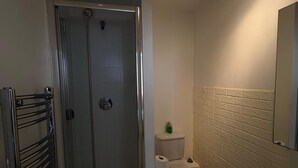 A bathroom with a glass shower enclosure, a toilet, and a bathtub. - Beautiful 2 Bedroom - Woolwich (London)