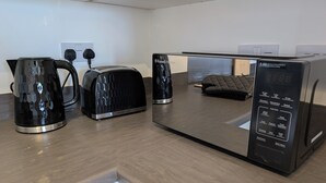 Cozinha moderna com torradeira, chaleira e micro-ondas.