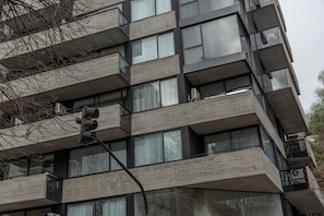 Un edificio de varios pisos con estilo arquitectónico moderno, con balcones y ventanas amplias.