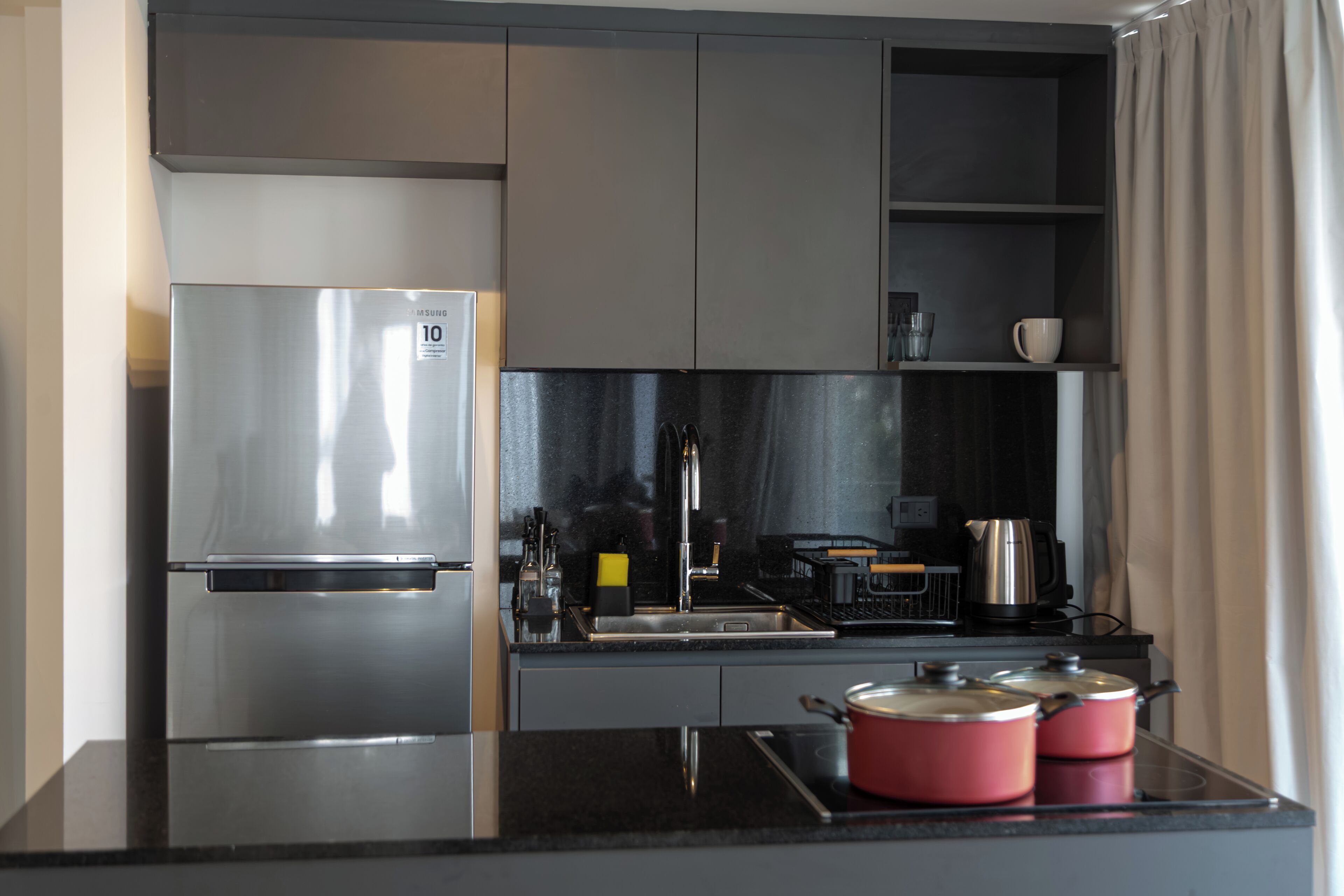 A modern kitchen with stainless steel appliances, including a refrigerator and a stove.