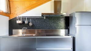 A modern kitchen with a stainless steel sink, a built-in oven, and a refrigerator. - Feleit 9 (Bormio)