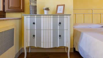 A room with a bed, a bedside table with a lamp, and a radiator.
