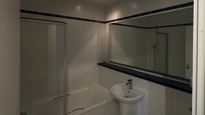 Een badkamer met een bad, wastafel en toilet.