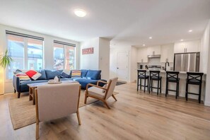 A modern apartment with a living area, kitchen, and dining space. - The Point Lodge | Cozy Invermere Getaway (Invermere)