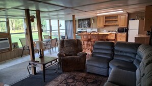 Ett kompakt bostadsutrymme med kök, matplats och sittgrupp.