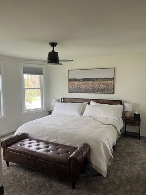 A bedroom with a bed, a headboard, a nightstand, a lamp, a window, and a ceiling fan. - Spacious Lancaster Retreat 4 bed 2 bath -sleeps 11 (Lancaster)