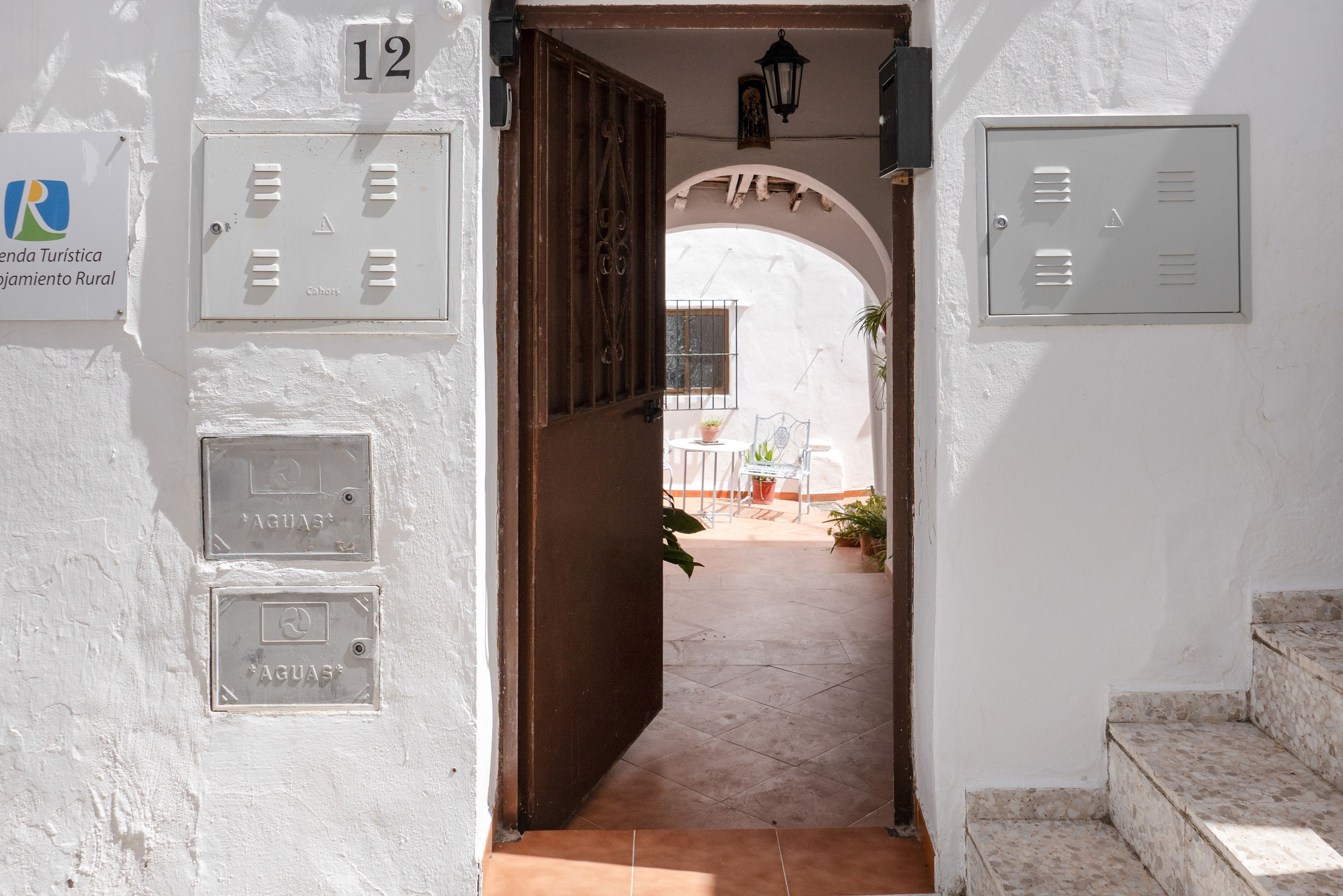 A corridor with a door leading to a patio area. There are signs indicating room numbers and amenities.