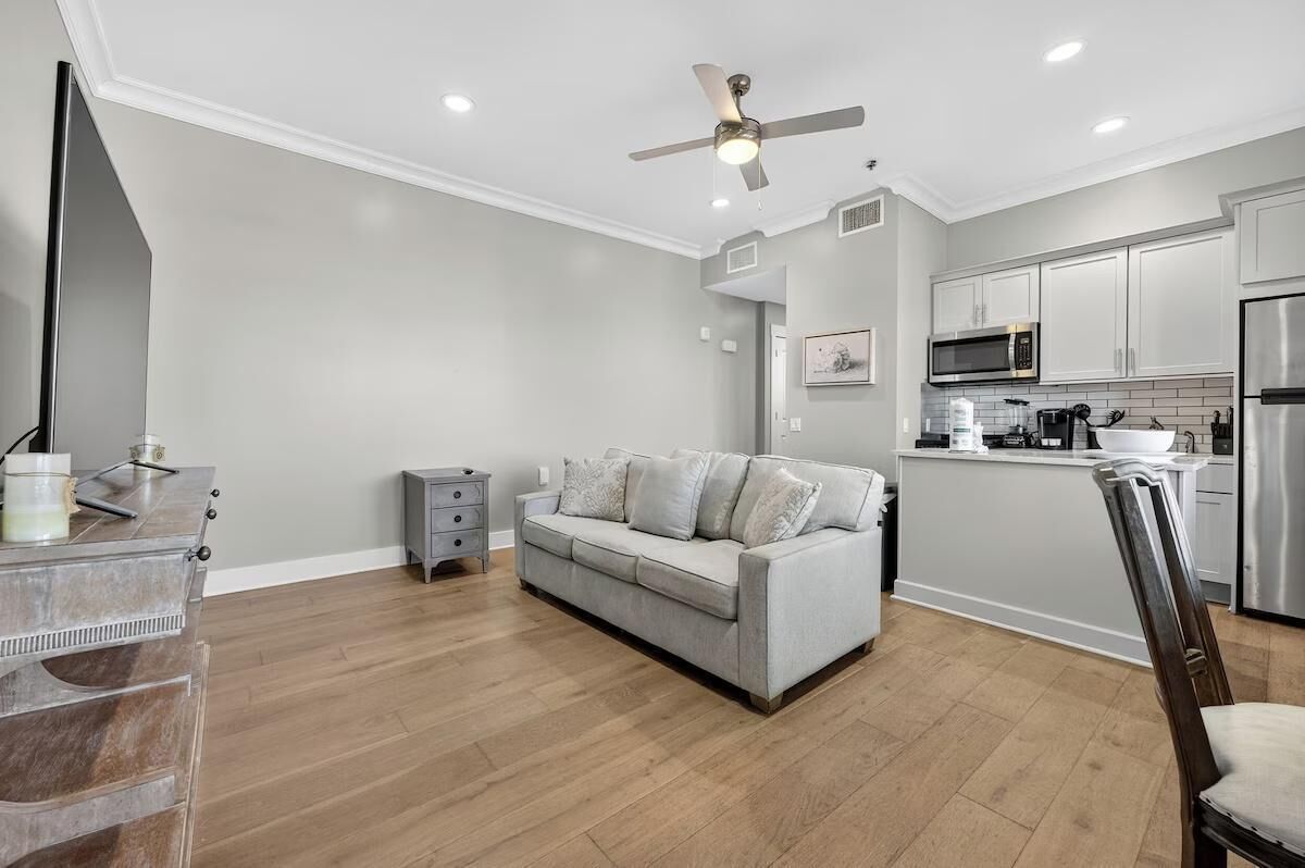 A modern kitchen with white cabinets, a microwave, and a refrigerator.