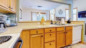 A kitchen with wooden cabinets, a stove, a sink, and a dishwasher. - FIREPLACE - 3BR Townhouse - Near Camelback Ski (Tannersville)