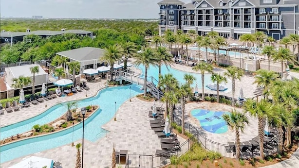 A hotel with a large swimming pool, palm trees, and a view of the ocean. - Henderson Beach Resort Lofts 104- Poolside Paradise (Destin)