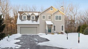 A two-story house with a garage, a front porch, and a driveway. - Cozy Home Near Waterpark - Hot Tub and Deck (Tannersville)