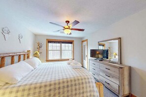 A bedroom with a bed, a ceiling fan, a dresser, a television, and a window. - Cozy Home Near Waterpark - Hot Tub and Deck (Tannersville)