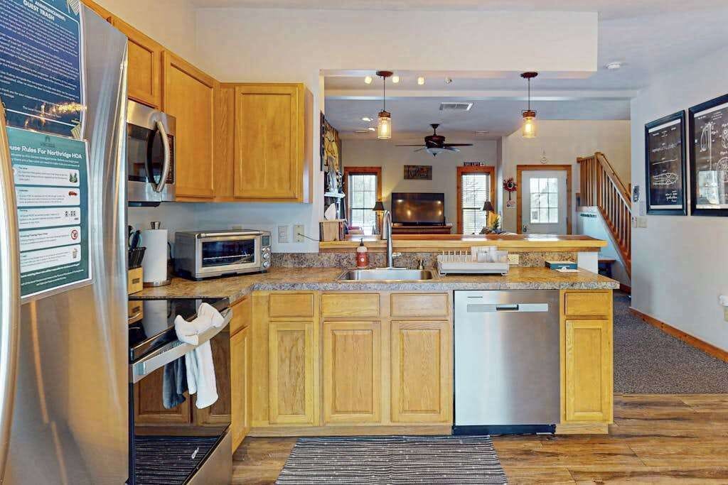 A kitchen with wooden cabinets, stainless steel appliances, and a central island.