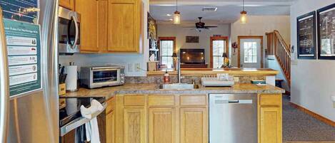Una cocina con armarios de madera, electrodomésticos de acero inoxidable y una isla central.